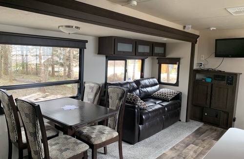 Clare House | Modern RV camper with all the perks Nestled in tree at lake edge